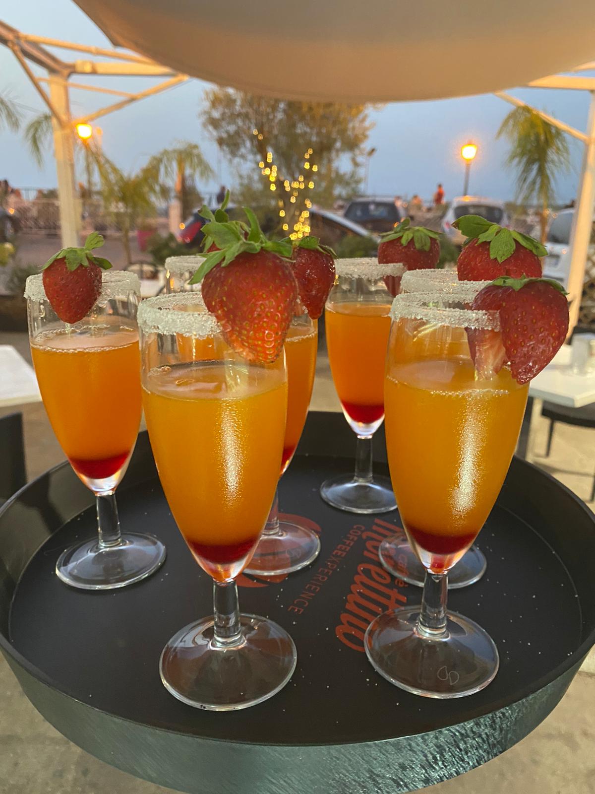Glasses on a Morettino tray on the terrace at dusk, palms and the sea behind
